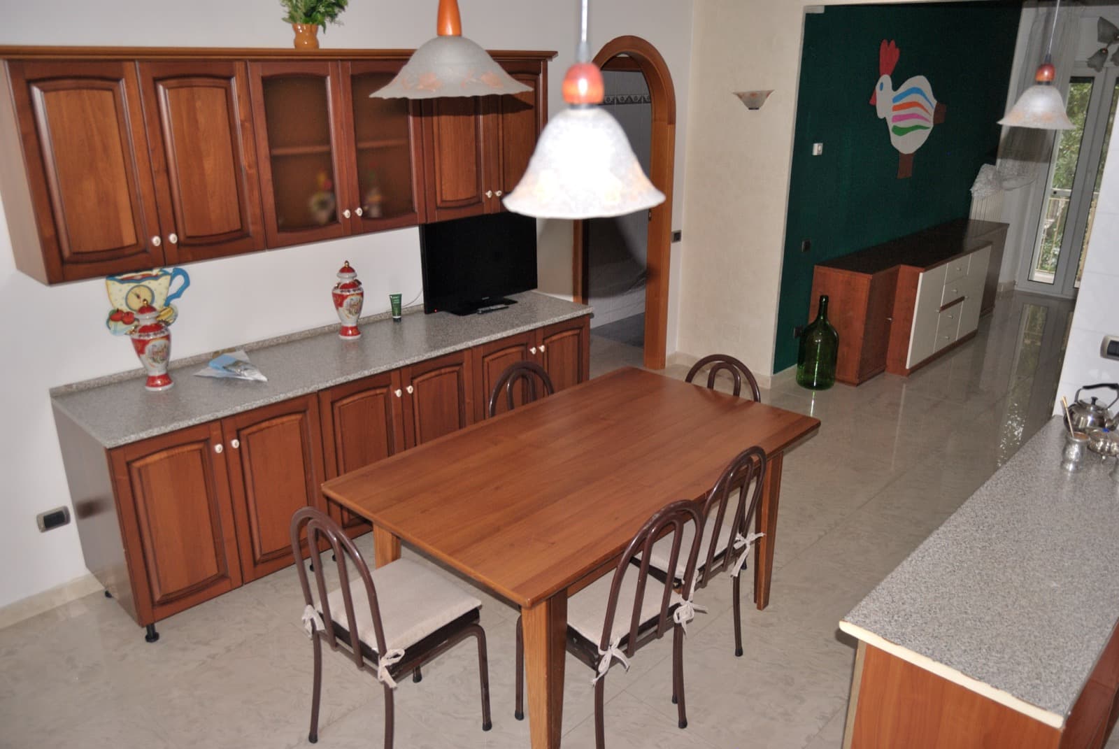 Cucina in noce massello e sala da pranzo con tavolo per 4