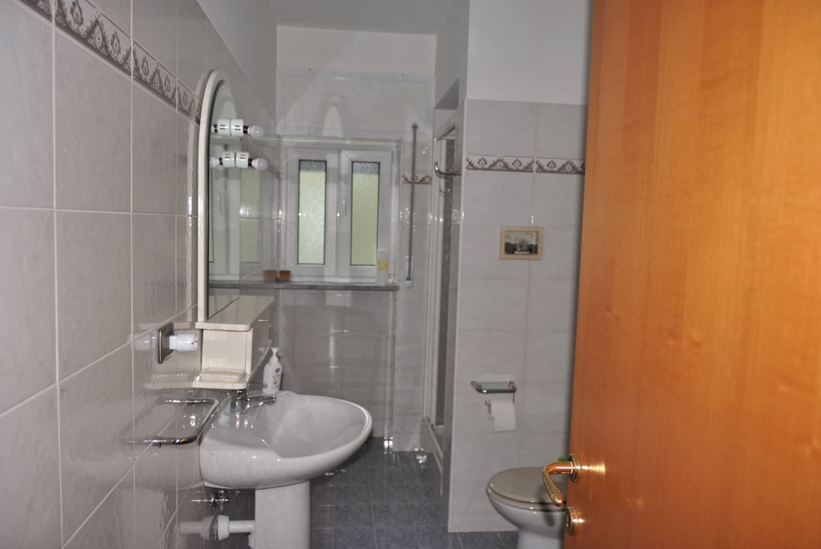 Bagno con doccia e piastrelle decorate
