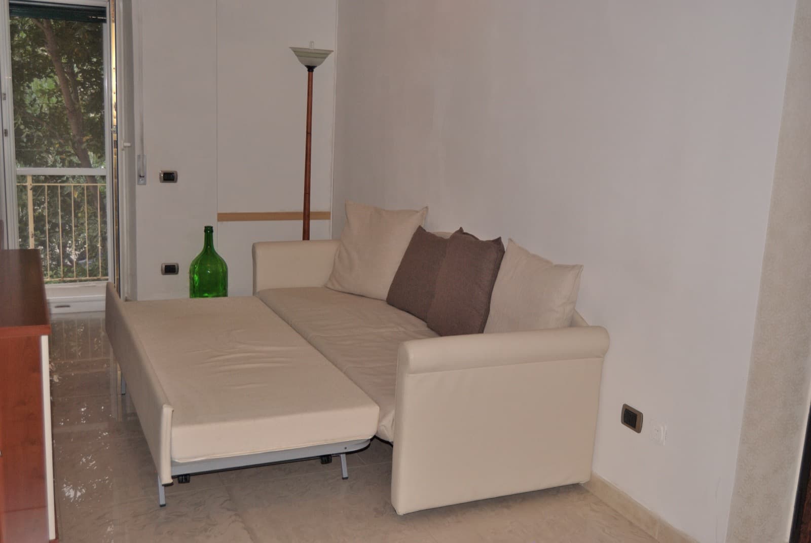 Soggiorno con divano letto e finestra sul verde